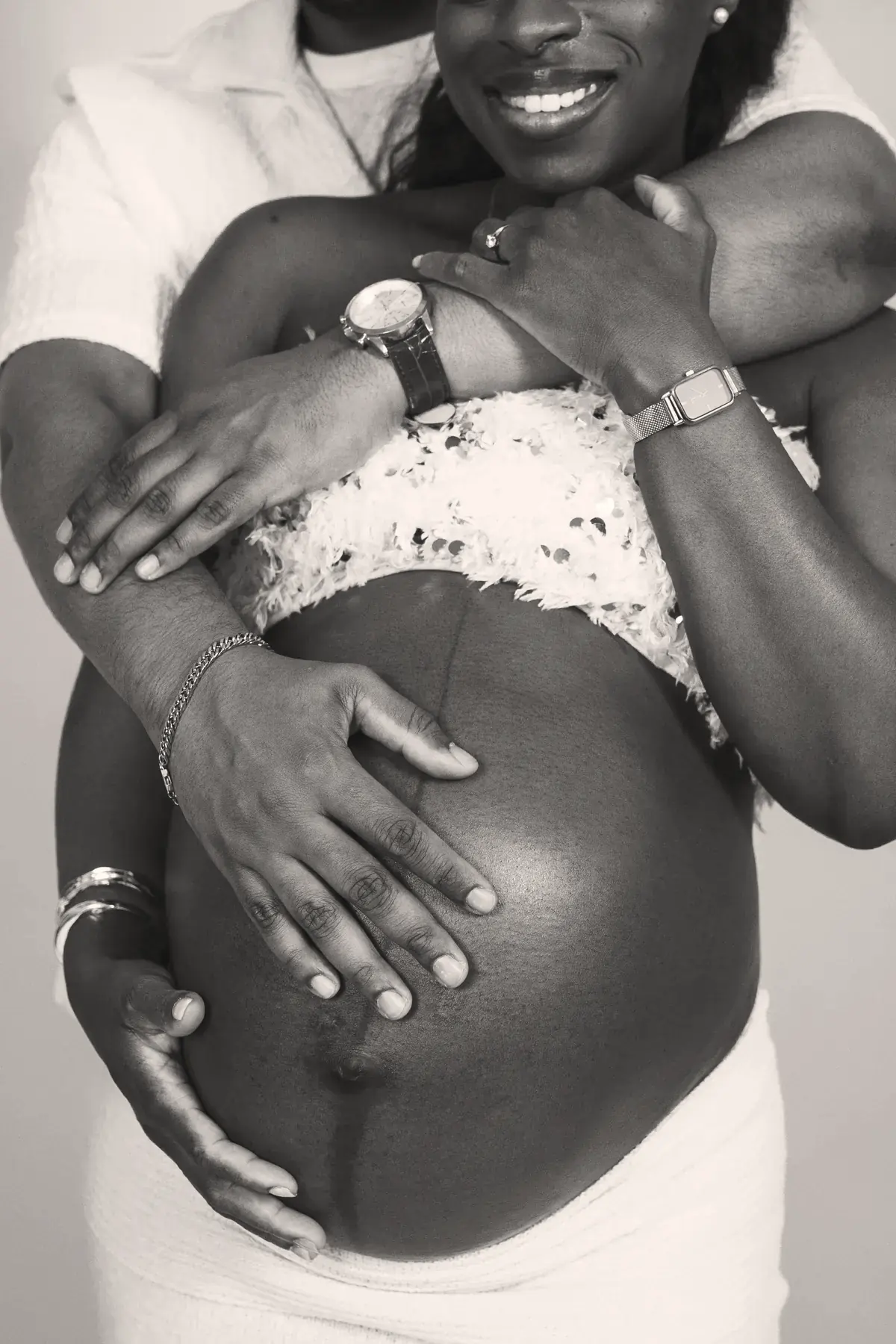 Future maman en chemise blanche, les mains sur son ventre