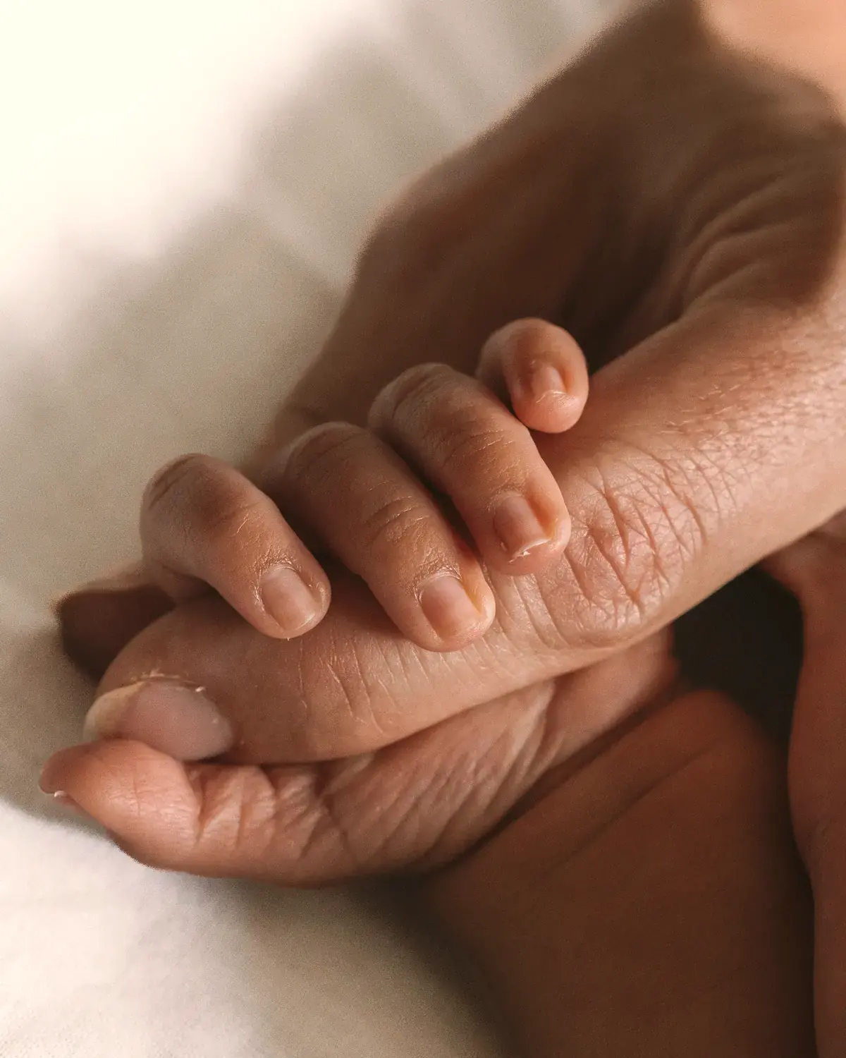 La main du nouveau-né posée dans celle de son parent